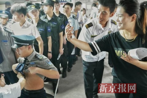 一女参检人员在现场拍照留念。新京报记者 王嘉宁 摄