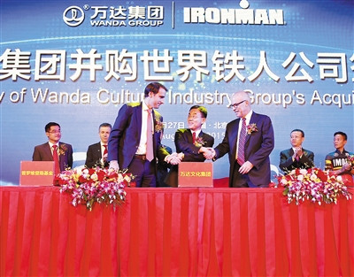 万达文化集团副总裁高群耀（中）与世界铁人公司CEO安德鲁·梅西克（右），集团以及普罗维登斯基金董事总经理戴维斯·诺埃尔（左）握手庆祝签约成功。并购图/厂商提供