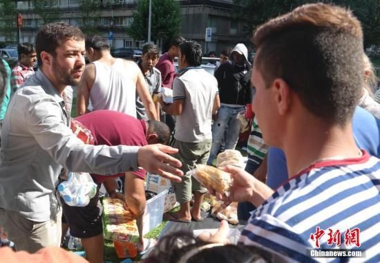 8月31日上午，欧盟总部所在地、比利时首都布鲁塞尔的市中心，部分来自叙利亚、伊拉克等战乱地区的难民在等待发放救济食品。中新社发 沈晨 摄