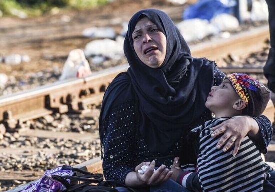 匈牙利封锁主要道路，匈牙一名来自中东的筑封堵难民妇孺抱着孩子痛哀。(法新社图片)