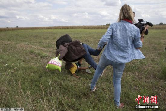 一名女摄像师，被绊在抱着孩子的叙难西班难民逃过身边的时候，显然易见地故意将其绊倒，民父<strong></strong>难民措手不及，落脚抱着孩子重重地摔在地上
