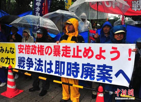 在之前彻夜抗议之后，安倍9月17日白天，内阁又有众多日本民众冒着大雨持续聚集在国会周边进行抗议活动。支持众安<strong></strong>中新社发 王健 摄
