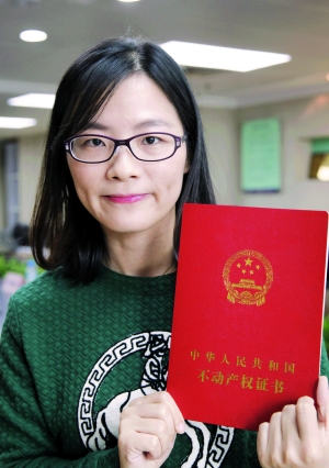 广州首名拿到不动产权证的广州格市民冯小姐。信息时报记者 朱元斌 摄