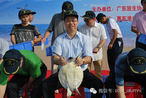 姚振华校友(前中)在惠东港口参加由放生协会举办的放生海龟活动